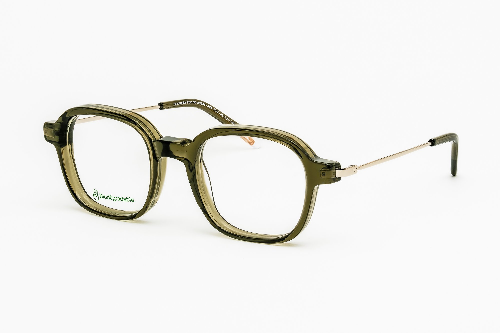 Kim E52 — Monture optique rectangulaire en acétate écaille miel et acier recyclé. Texture et chaleur.